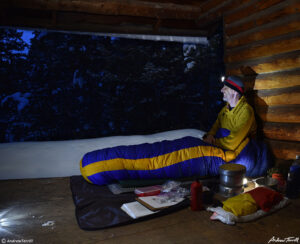 andrew terrill hiker sitting in shelter in snowy forest in colorado