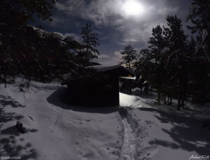 appalachian lean to shelter beneath moon in forest and snow in golden gate canyon state park colorado