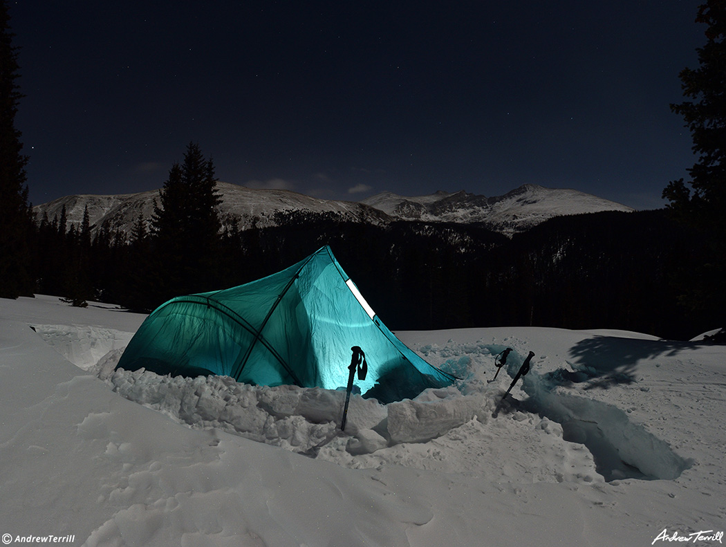 glowing tent in snow during a winter night in rocky mountains colorado