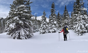 hiker hiking on snowshoes in deep snow in colorado winter mountains