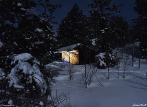 lights in appalachian lean to shelter in moonlit winter forest in golden gate canyon state park colorado