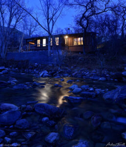 a cabin by a creek in colorado at night