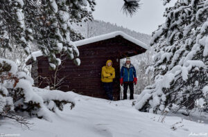 andrew terrill and igloo ed beside wooden cabin colorado