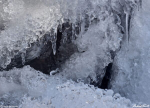 close up of rocks and ice with icicles in mountain creek winter