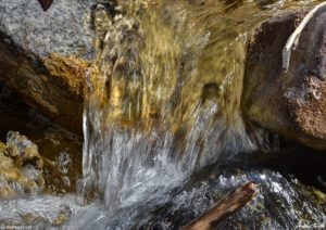 water gushing between rocks small waterfall