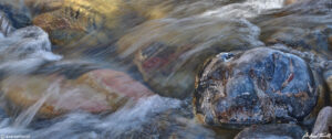 water in motion rushing in mountain river passed glistening rock