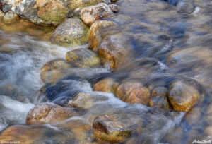 water rushing over river rocks and pebbles