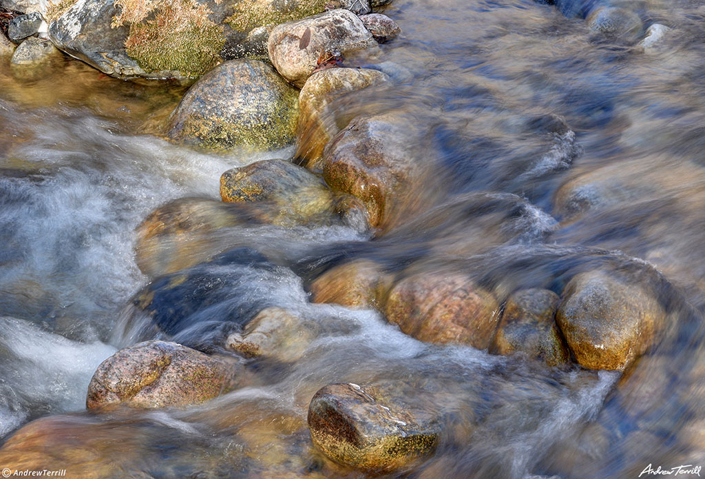 water rushing over river rocks and pebbles