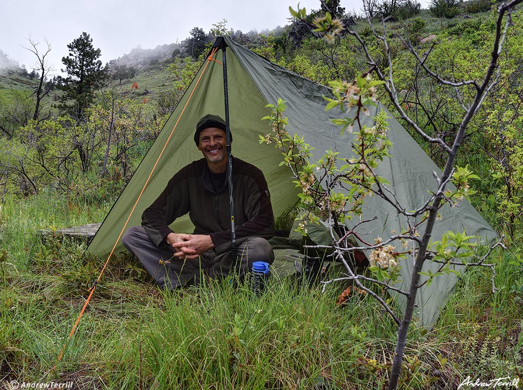 andrew terrill backpacker camping under tarp in the rain