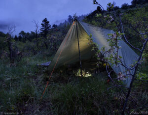 tarp wild camping in gloomy wet evening rocky mountains