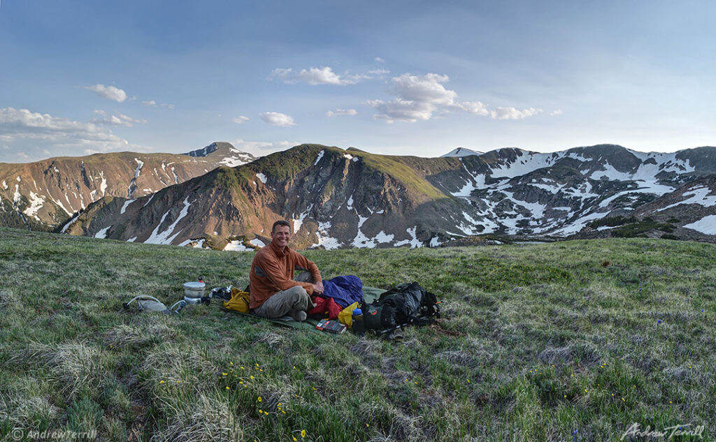 andrew terrill sitting on hillside in rocky mountains