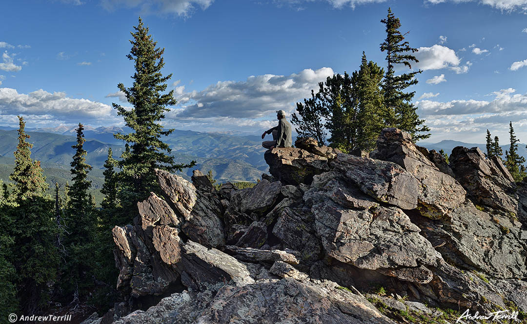 hiker sitting on rock looking at view colorado front range