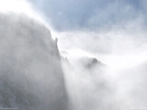 high winds in rocky mountains with clouds spindrift and snow