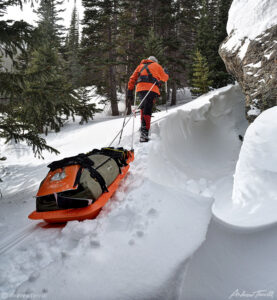 igloo ed pulling a pulk along crest of snowdrift