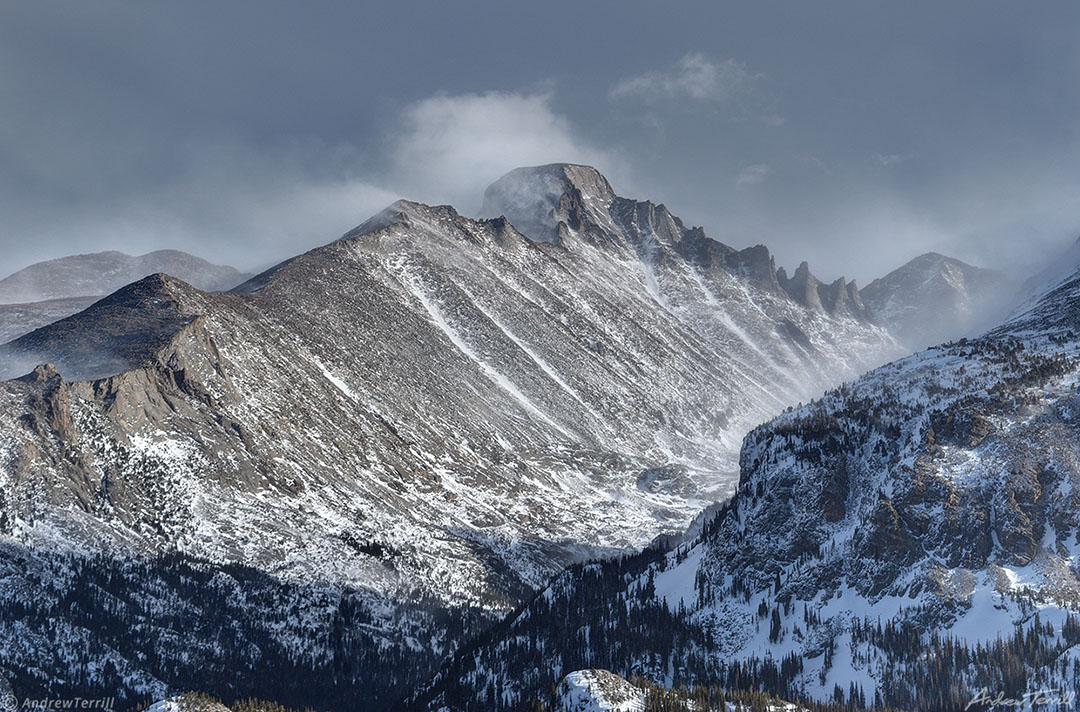 longs peak in winter with spindrift and dark clouds