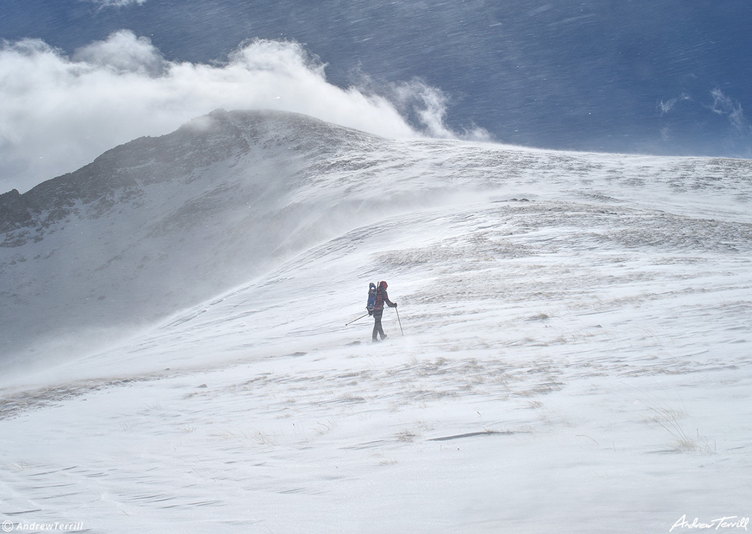 006 small figure heading up mount bierstadt on a windy day with spindrift colorado