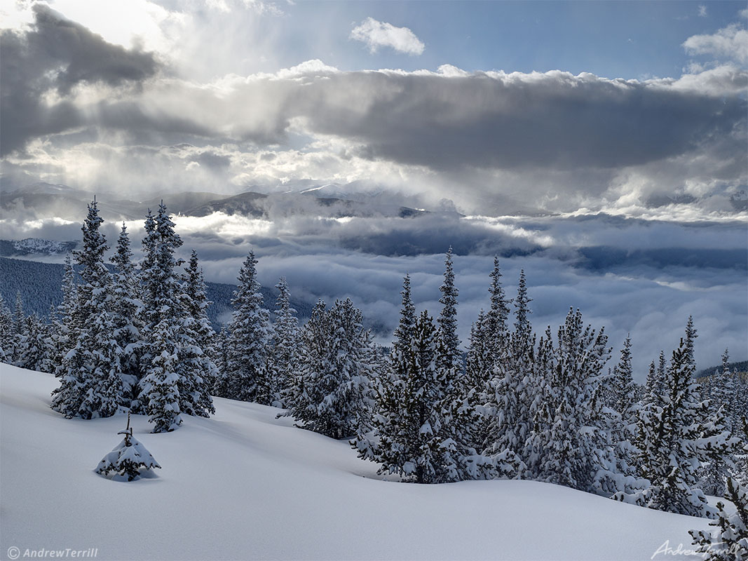  winter snow on mountains and forests in colorado above clearing storm clouds