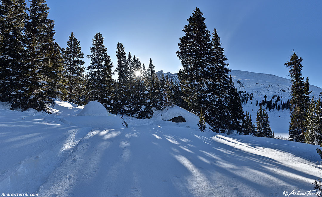 The sun appears over the ridge.